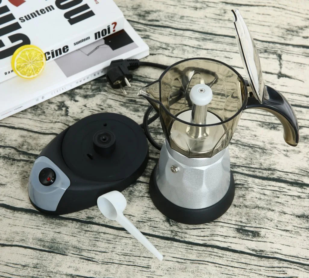 Electric moka pot with silver metal base, transparent top, and black charging dock with power switch.
