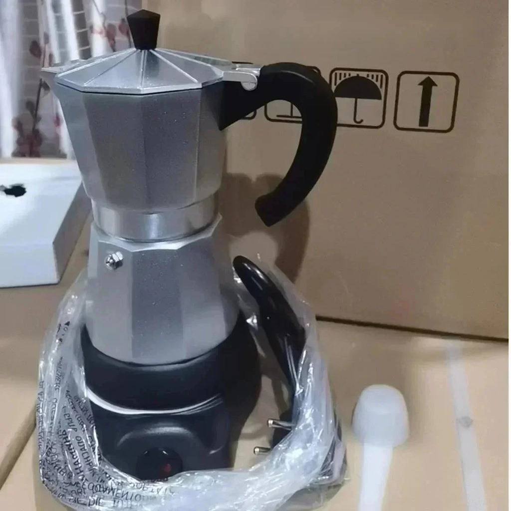 Electric silver aluminum moka pot coffee maker on a black power base with black handle, new in box packaging.