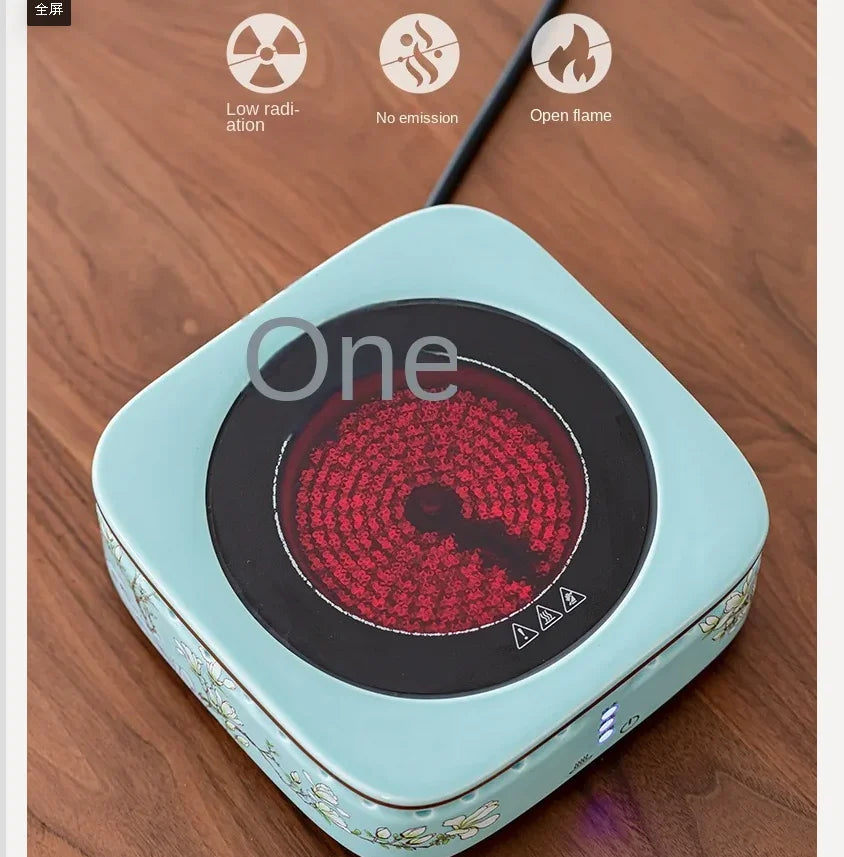 Portable light blue floral electric tea stove burner with a circular heated element on a wooden table.