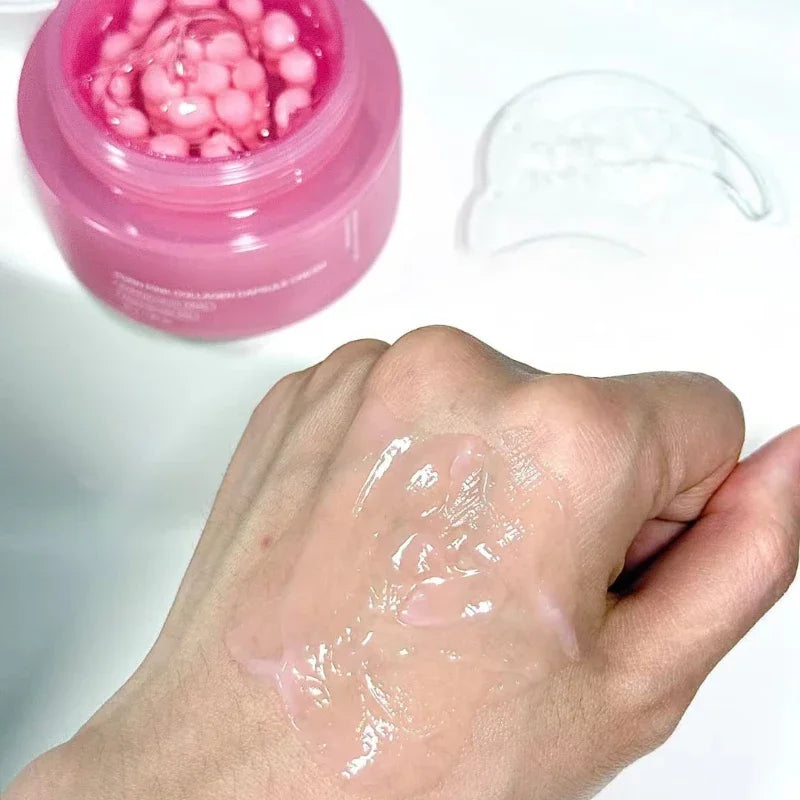 Pink jar of collagen capsule cream shown with a swatch of the clear, pink-tinted gel product on a person's hand.