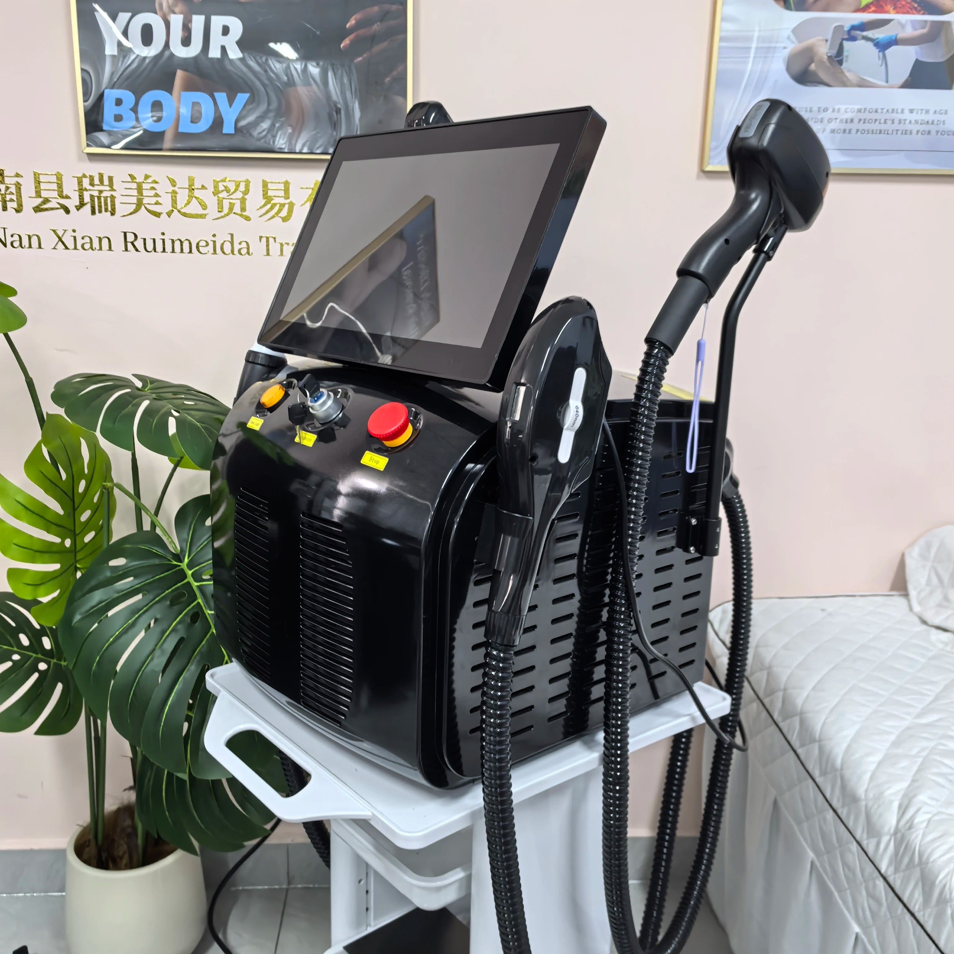 Black laser removal machine with touchscreen and three connected handpieces on stand