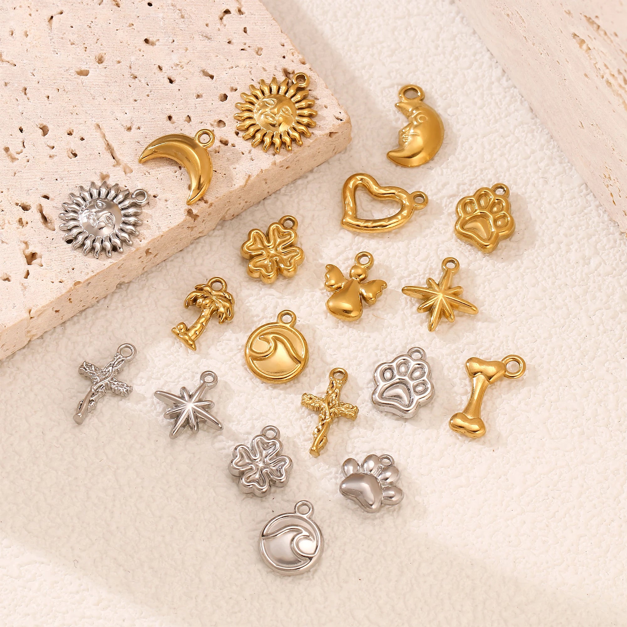 Gold and silver stainless steel pet paw, wave, and star charms for DIY jewelry making and pet-themed necklaces.