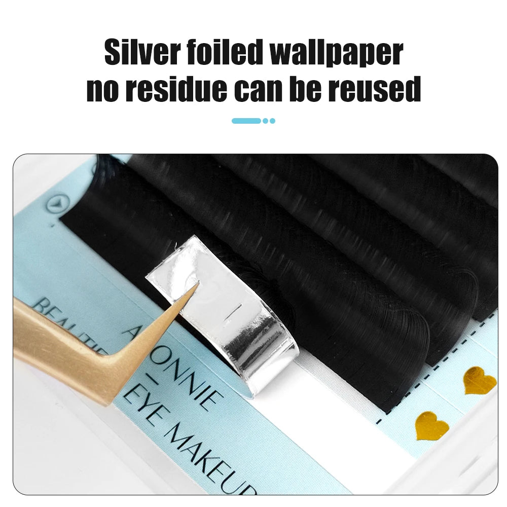 Ultra matte black individual eyelash extensions on a reusable silver foil adhesive strip with gold tweezers.