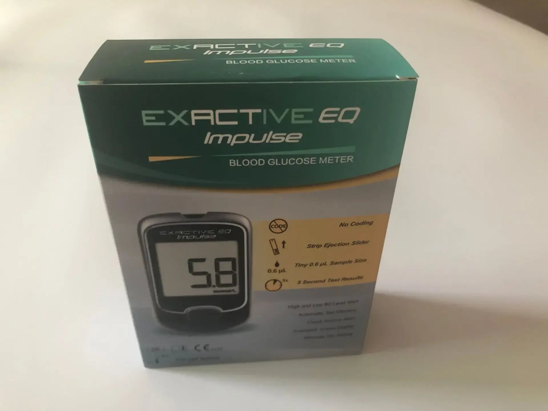 EXACTIVE EQ Impulse blood glucose meter box with diabetes test strip features shown on green and white packaging.