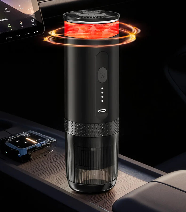 Portable black electric coffee maker with a transparent cup, glowing heat indicator, and USB-C port in a car console.