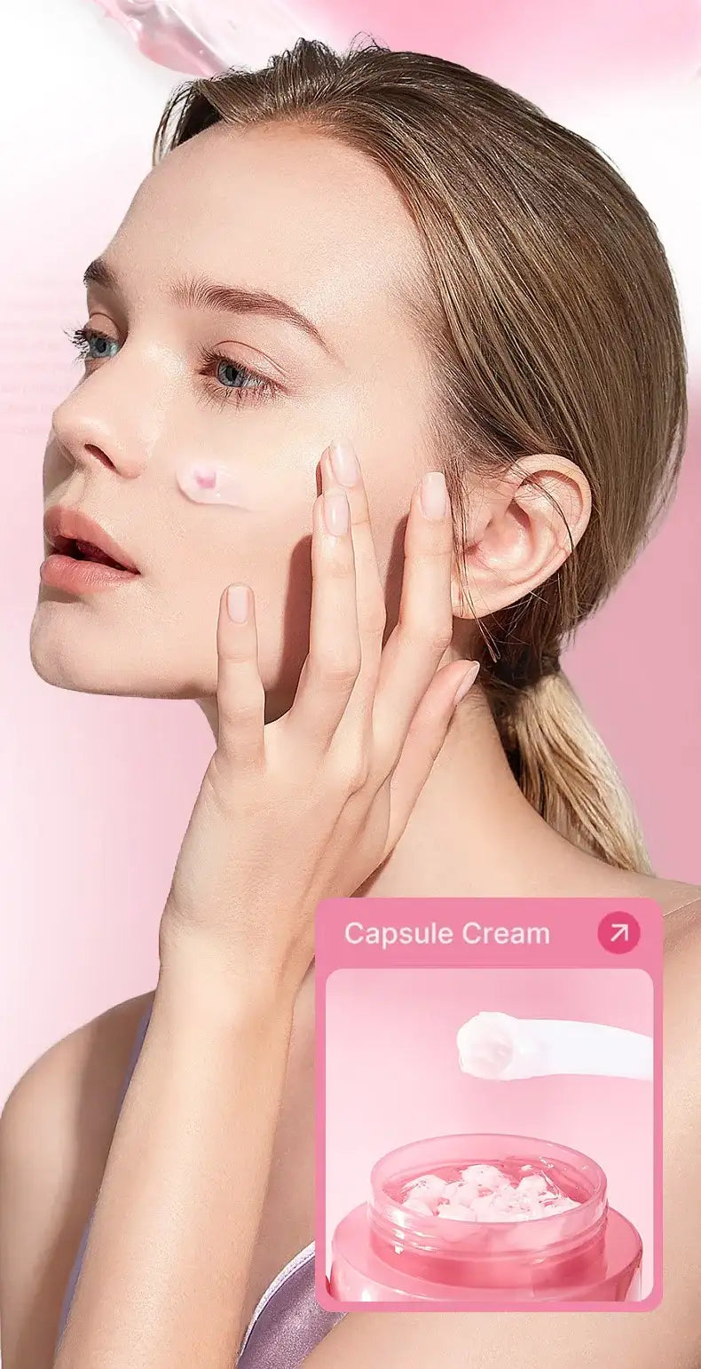 A woman applying light pink, collagen-infused capsule cream to her cheek against a pink background.