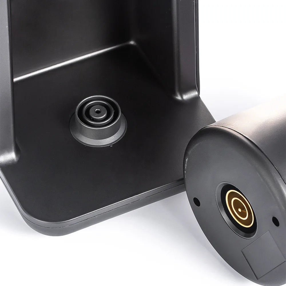 Black matte electric kettle base with gold-tone contact pin connection for cordless, rapid heating design.