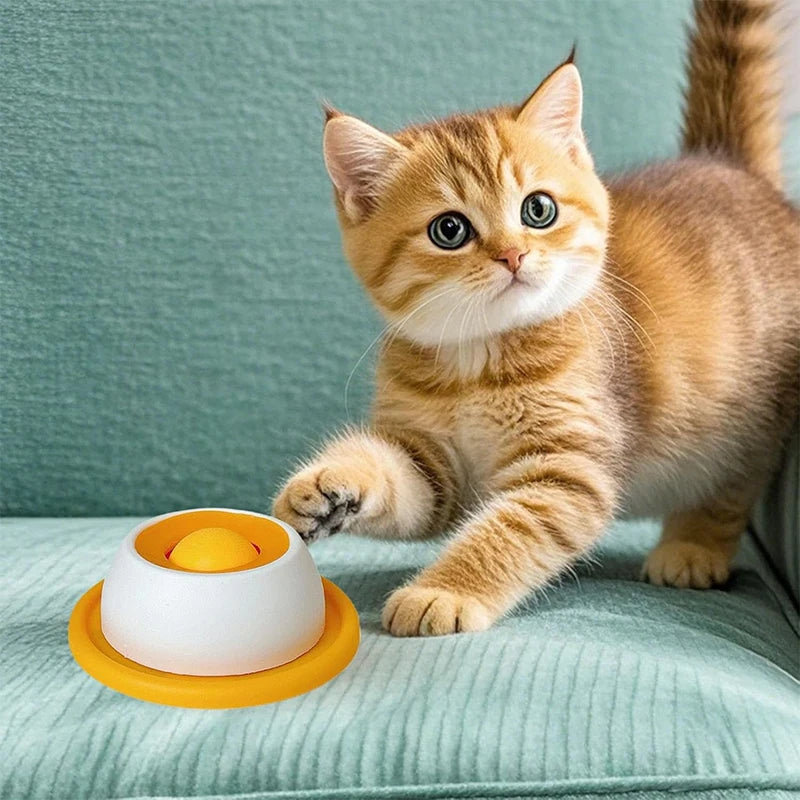 Tabby kitten playing with yellow and white interactive dental lick mat, a non-slip slow feeder for mental enrichment.