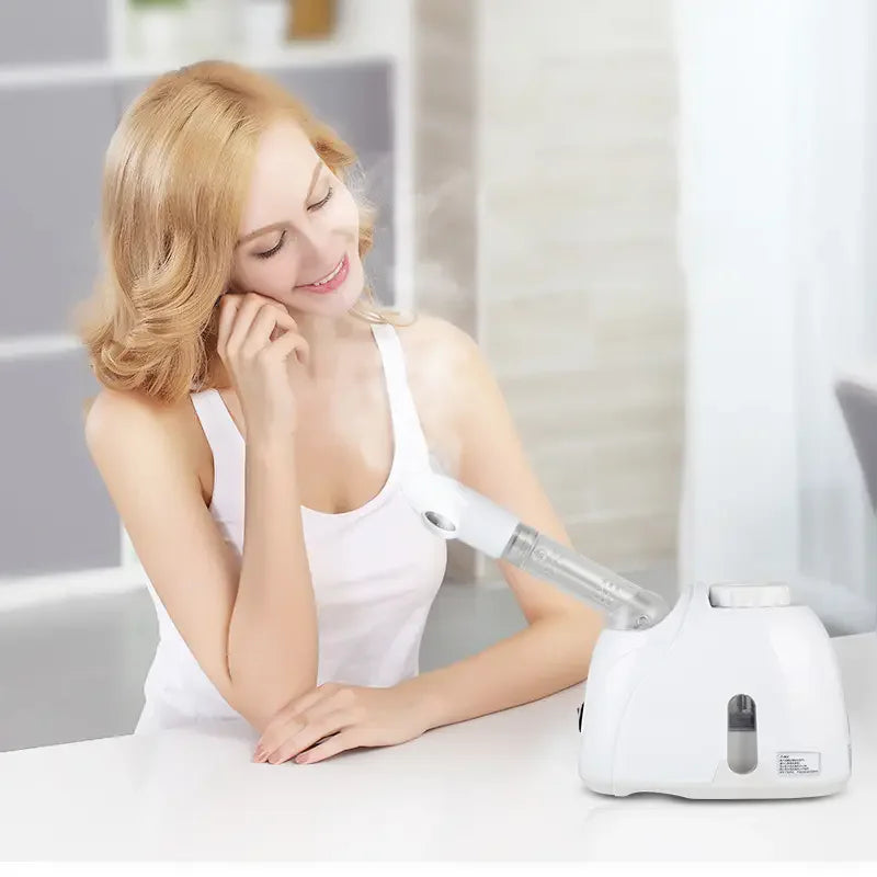 Woman using white portable facial steamer with ozone mist for home skin care and spa treatment.