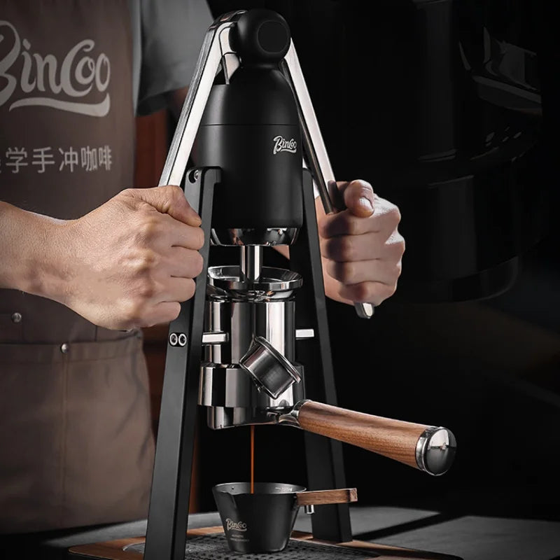 Bincoo manual espresso maker with black frame, stainless steel components, and wooden handle brewing fresh coffee.