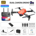 Black and orange 4K dual-camera drone with remote control, spare blades, protective frames, battery, and storage case.