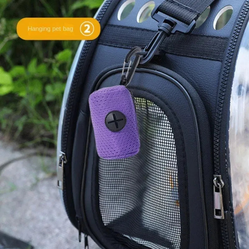 Purple mesh dog poop bag dispenser hanging on a pet carrier for easy access during walks.