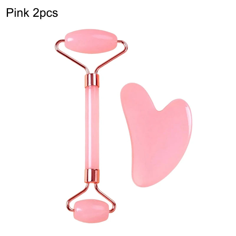 A pink jade facial roller and a heart-shaped gua sha massage tool with gold-tone metal accents.