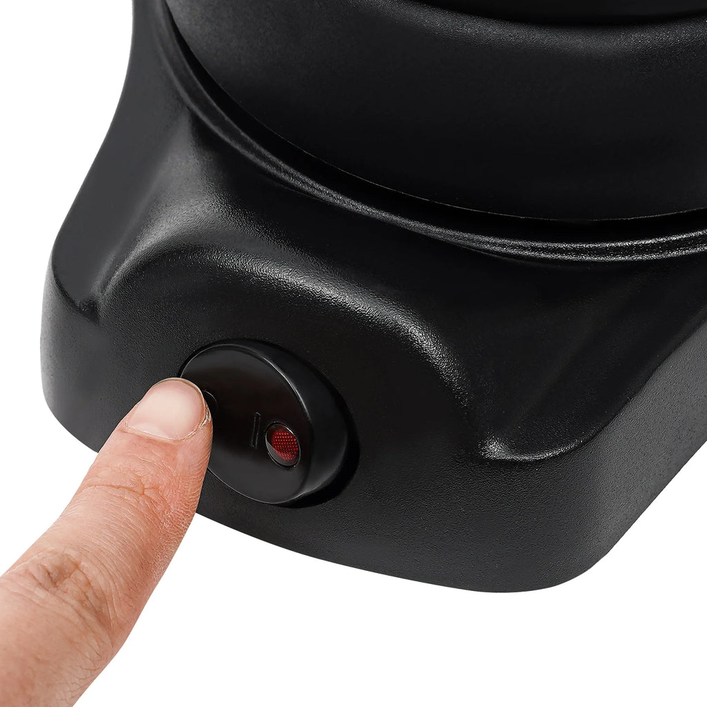 Finger pressing the power button on a matte black plastic coffee maker with a red indicator light.