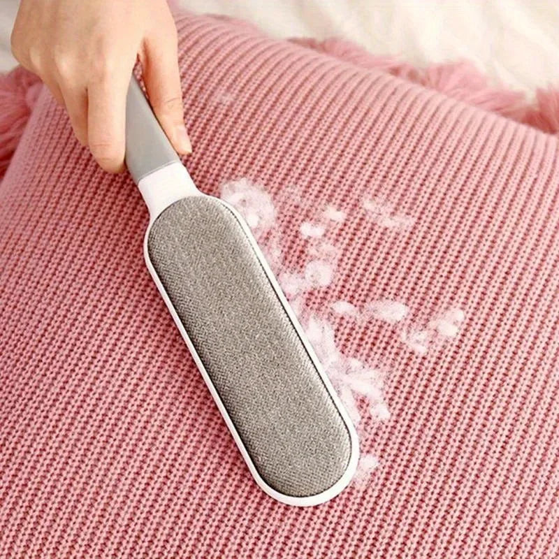 Reusable double-sided pet hair remover brush cleaning fur and lint from a pink knit pillow.