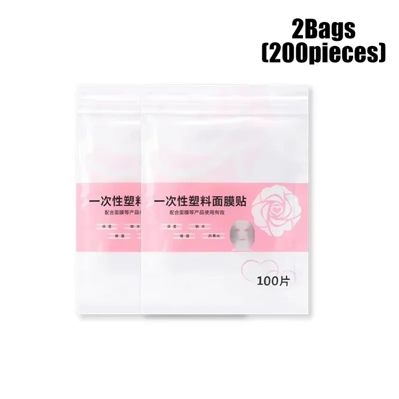 Two clear plastic bags of disposable facial mask sheets, each with a pink label showing 100 pieces for a 200 total.