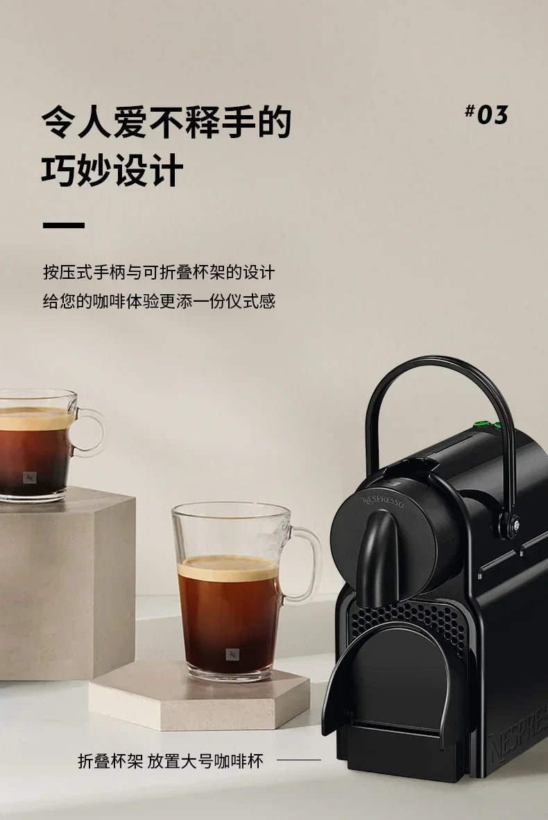 Black Nespresso coffee machine with foldable cup tray and two glass mugs on neutral pedestal stands.