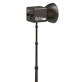 Black G60 studio LED light with reflector mounted on a telescopic metal tripod stand for photography and video lighting.