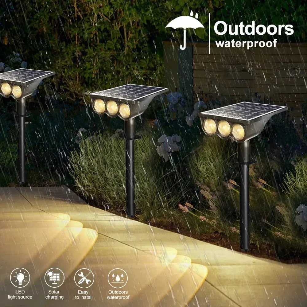Black waterproof solar LED landscape spotlights with top solar panels illuminating a walkway in rain.