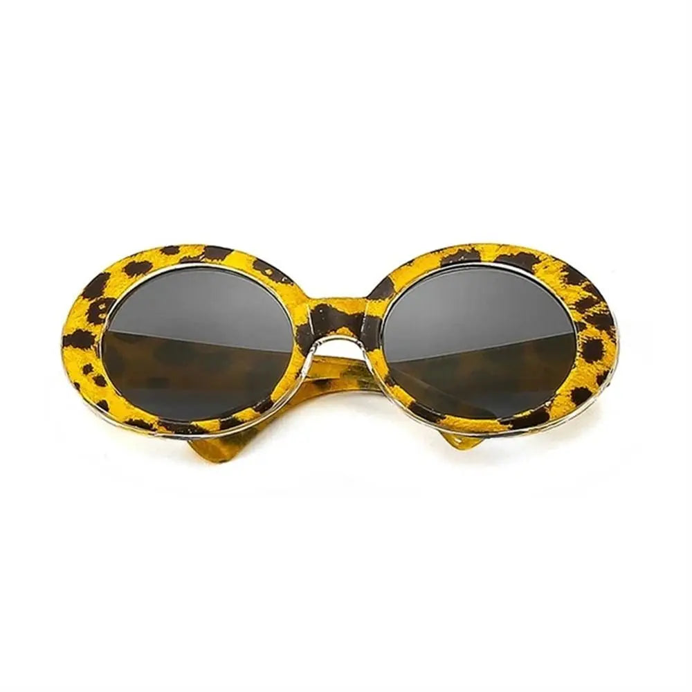 Mini round doll sunglasses with yellow leopard print frames and dark lenses, isolated on a white background.