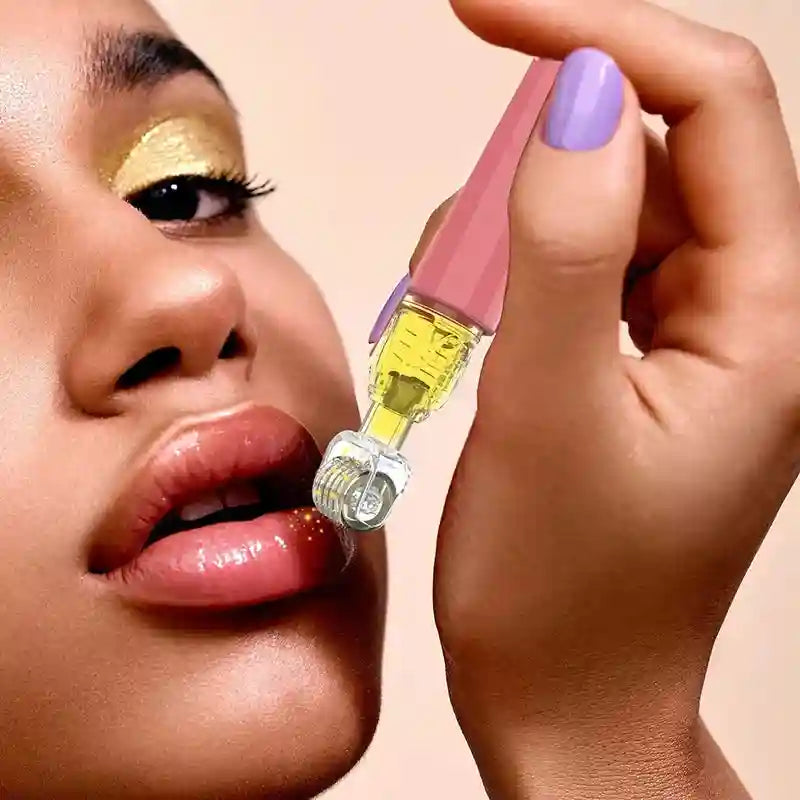 A hand holding a rose-gold derma roller with a serum-filled barrel being applied to a person’s glossy lips.