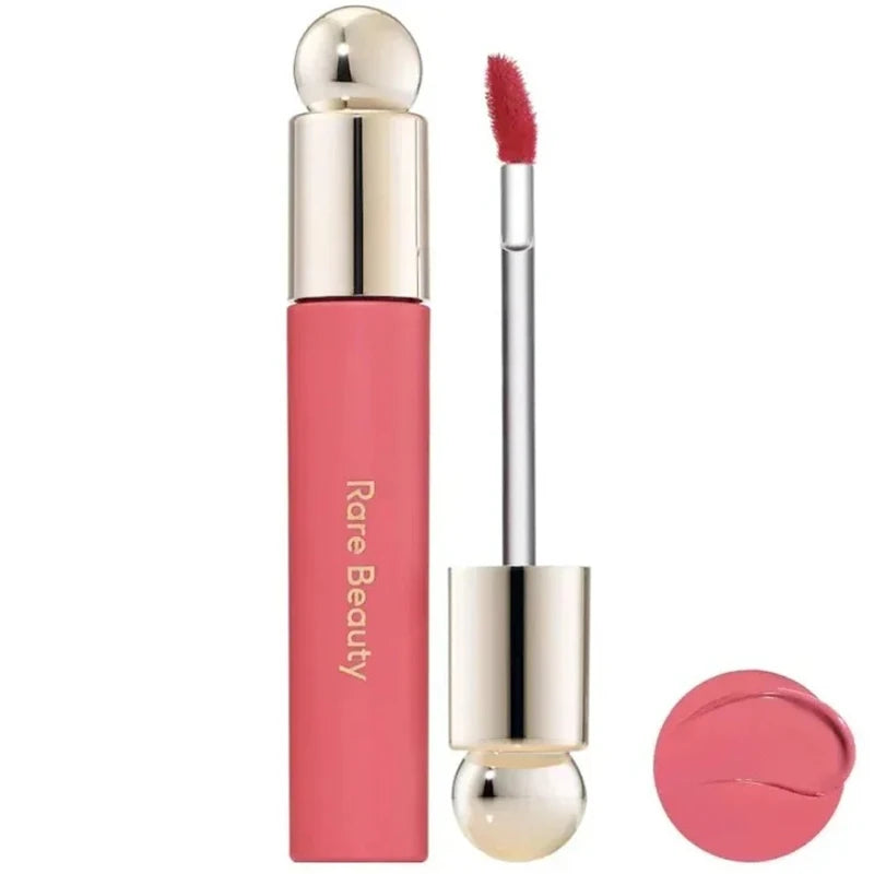 Rare Beauty Soft Pinch Tinted Lip Oil in a pink shade with gold cap, doe-foot applicator, and glossy product swatch.