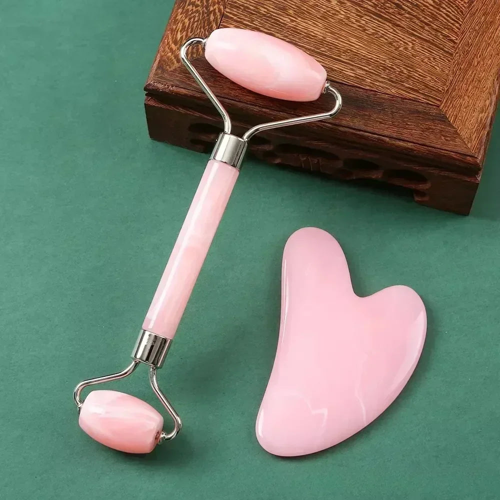 Pink resin jade facial roller and heart-shaped gua sha tool for anti-wrinkle skin care and face massage.