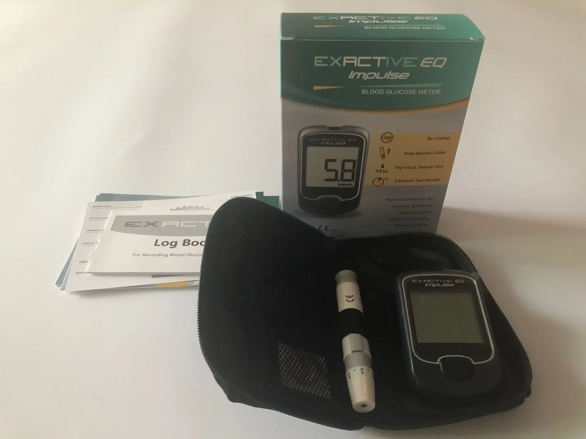 EXACTIVE EQ Impulse blood glucose meter kit with black case, lancing device, test strips, and instruction logbook.