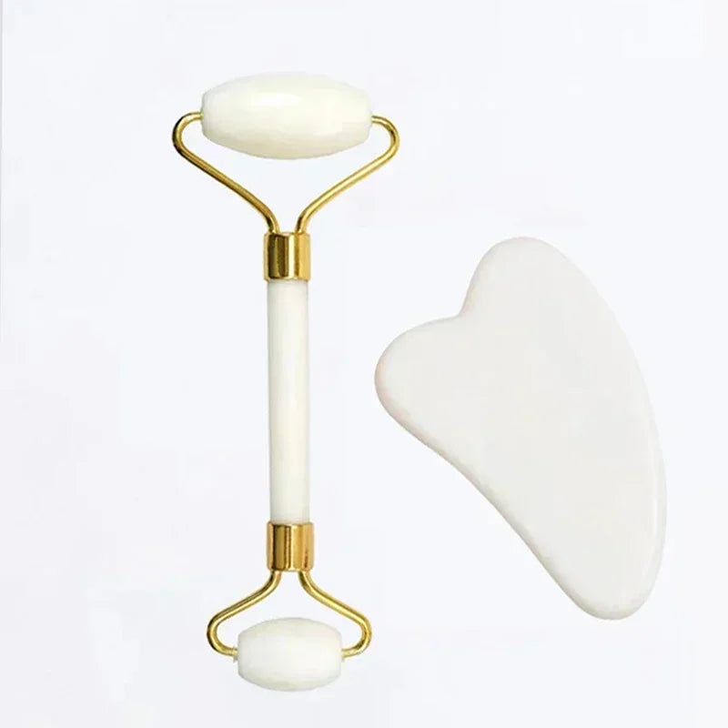 White jade facial roller and heart-shaped gua sha scraping tool for skincare massage.