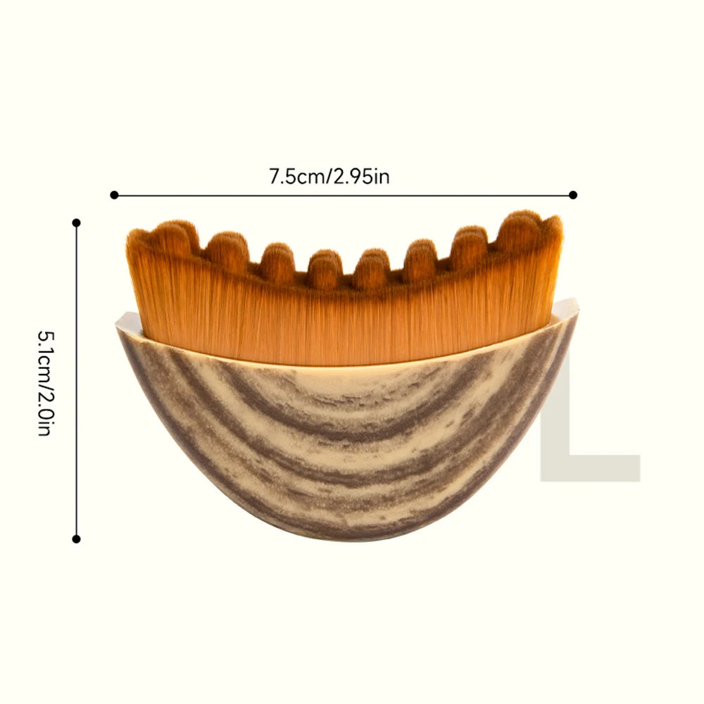 Curved lymphatic facial massage brush with brown, scalloped-edge bristles and a marbled, semi-circular handle.