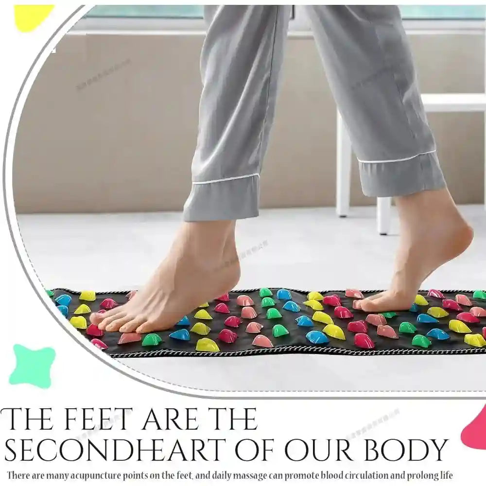A black foot massage mat with colorful plastic, pebble-shaped acupressure nodes for reflexology therapy.