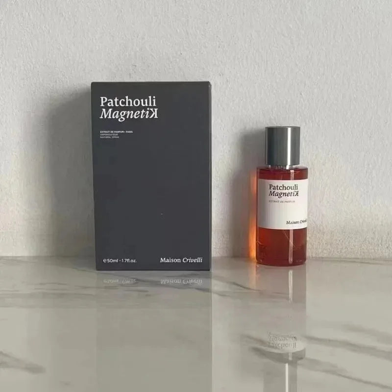 50ml Patchouli Magnetik perfume and black box on a marble surface. The amber glass bottle has a silver cap.