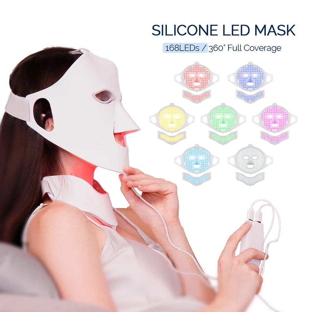 A woman wearing a white, flexible silicone face and neck LED mask with a handheld controller showing 7 color modes.