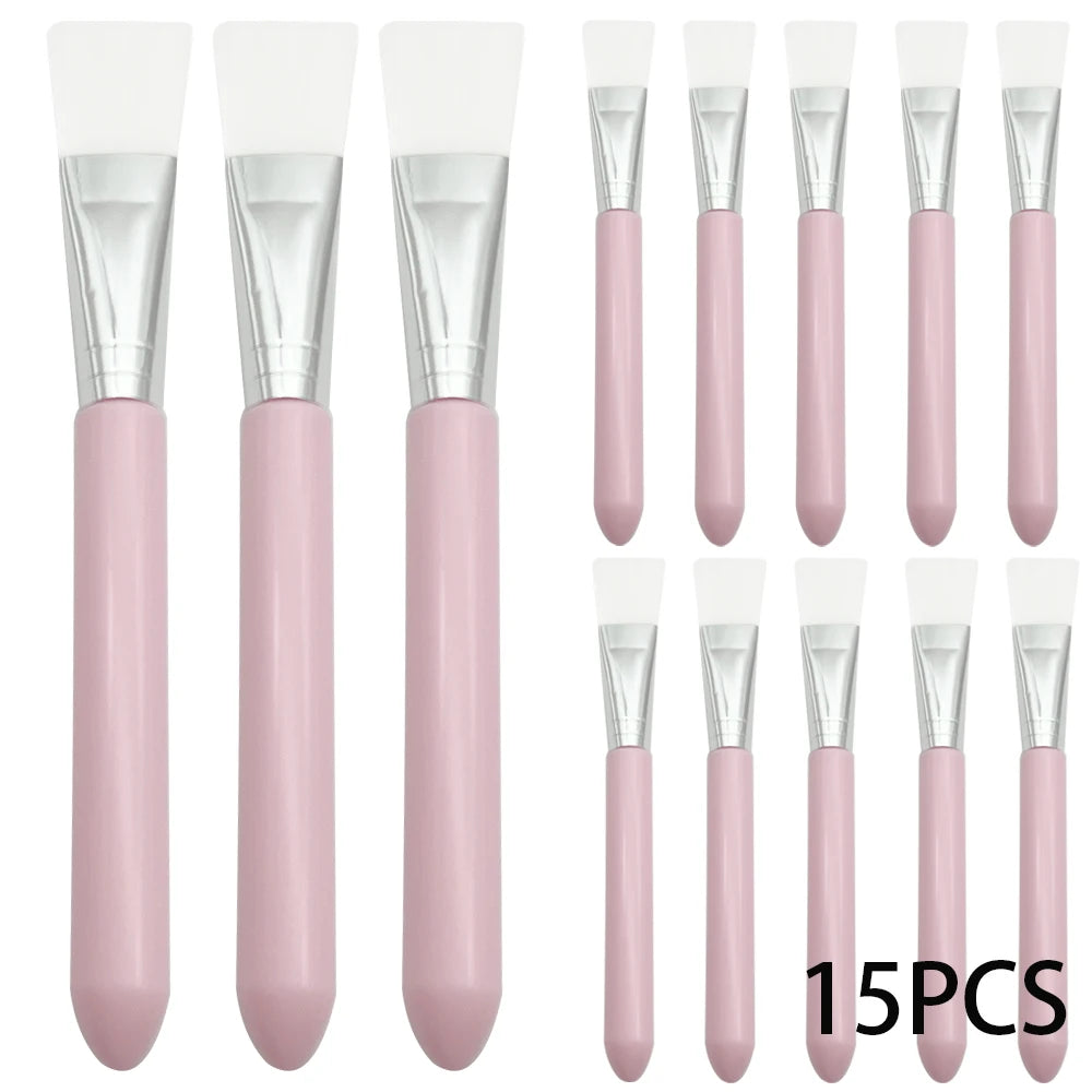 Set of 15 face mask brushes with white silicone heads, silver ferrules, and smooth pastel pink handles.