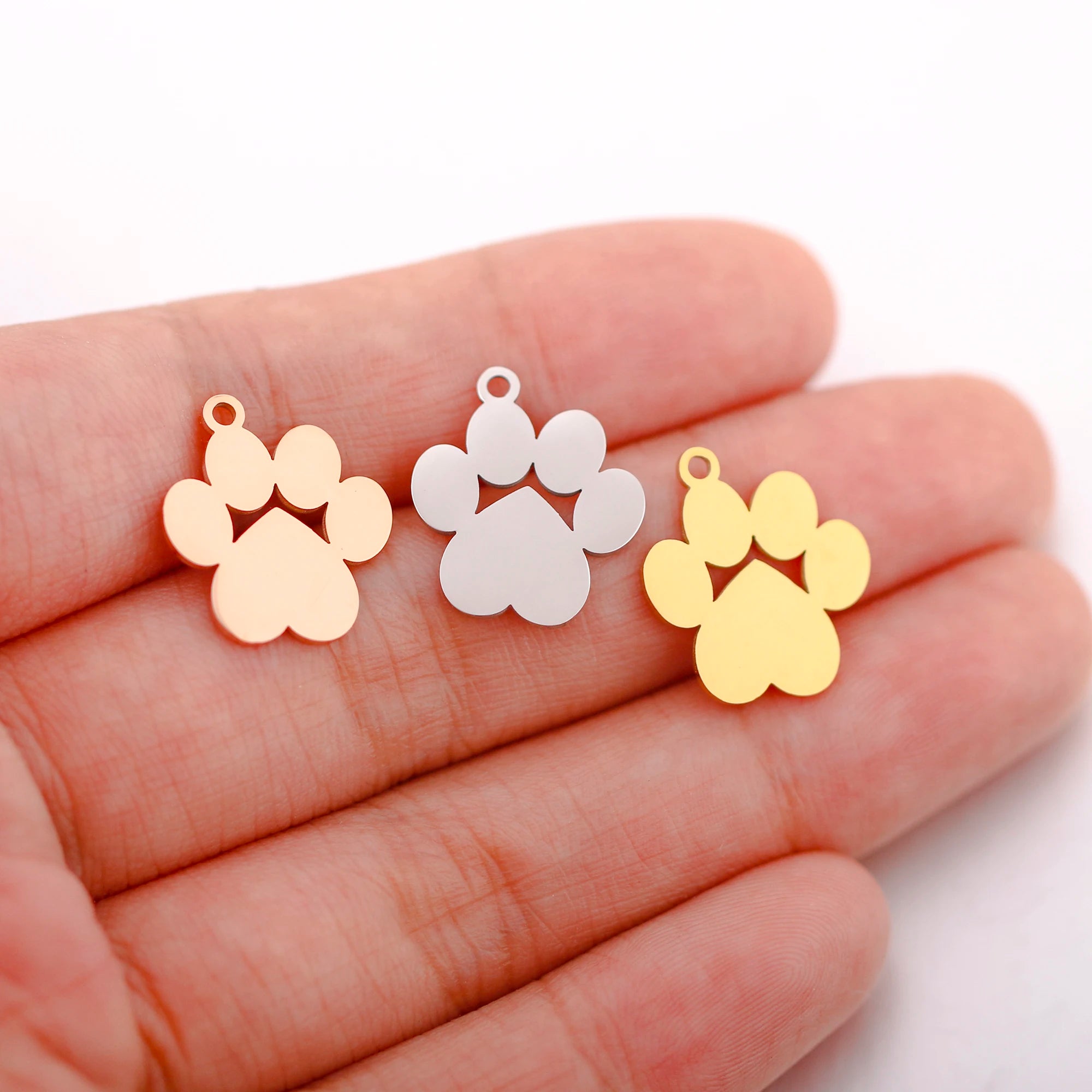 Gold, silver, rose gold stainless steel dog paw print charms for DIY pet jewelry making, necklaces, and bracelets.
