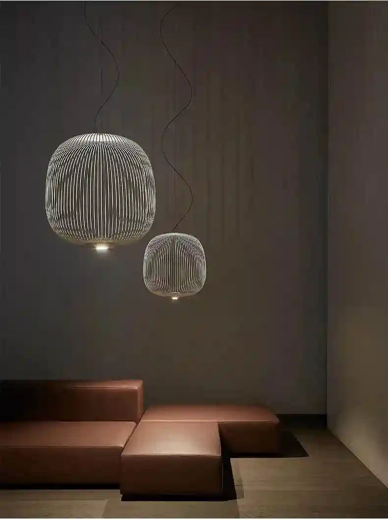 Two spherical, ribbed white wire cage pendant lights suspended at different heights to illuminate a living space.