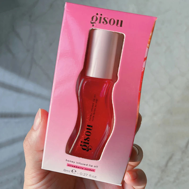 Gisou Honey Infused Lip Oil in Strawberry Sorbet, a glossy, red plumping lip treatment in pink packaging.