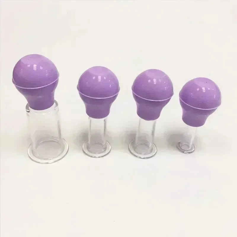 Four purple rubber-bulb facial cupping massage tools of varying sizes with clear glass cups on a white background.