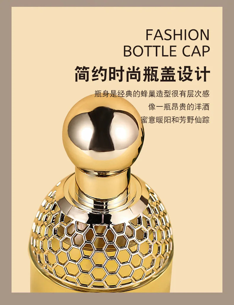 Gold perfume bottle cap with a smooth spherical top and a textured, honeycomb-patterned base.