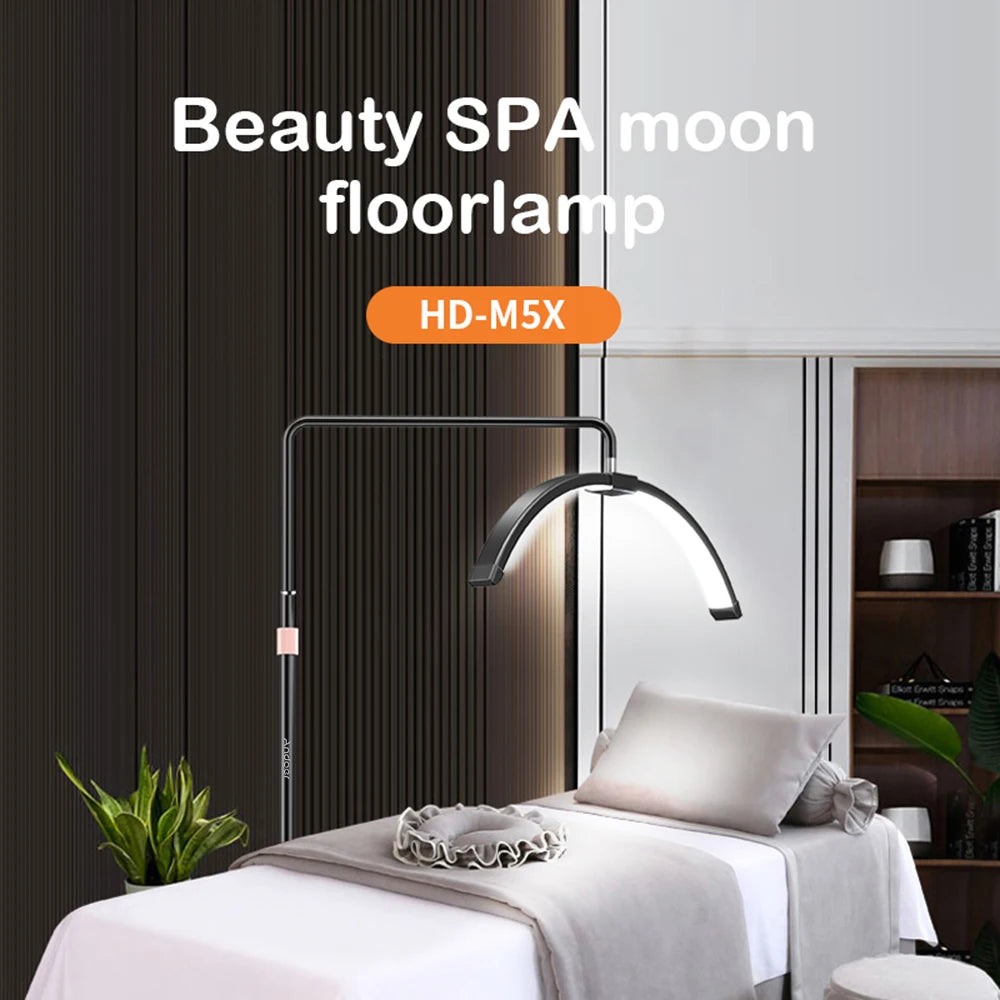 Black, crescent-shaped LED floor lamp on a tall, adjustable metal stand for professional spa or beauty treatments.