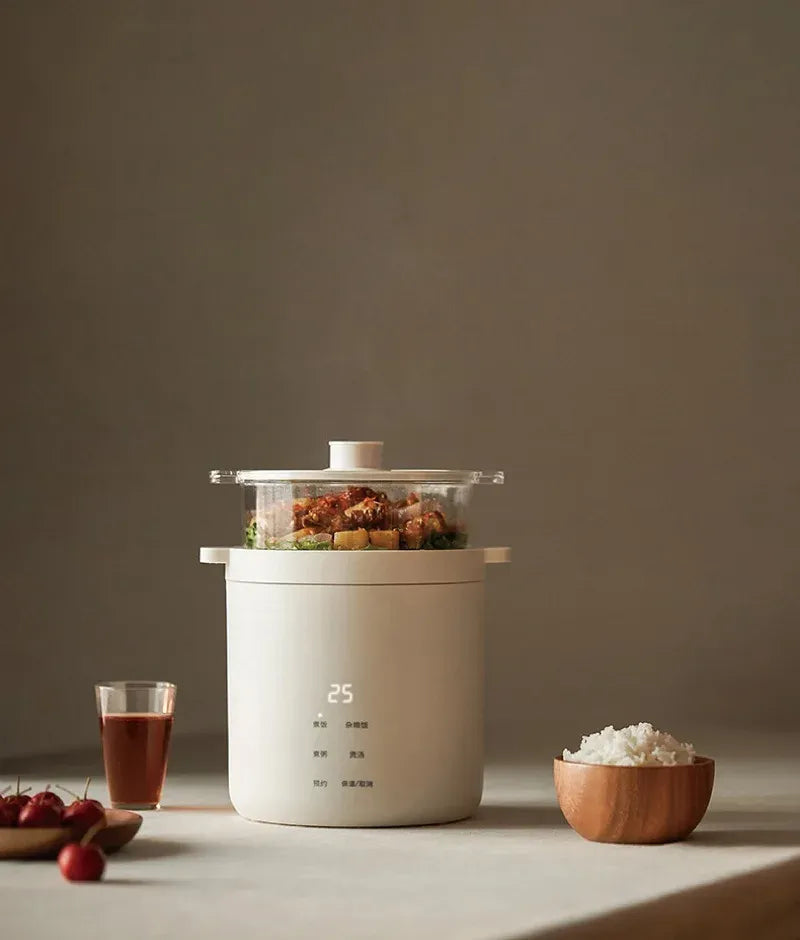 White electric rice cooker on countertop with lid open and food steaming