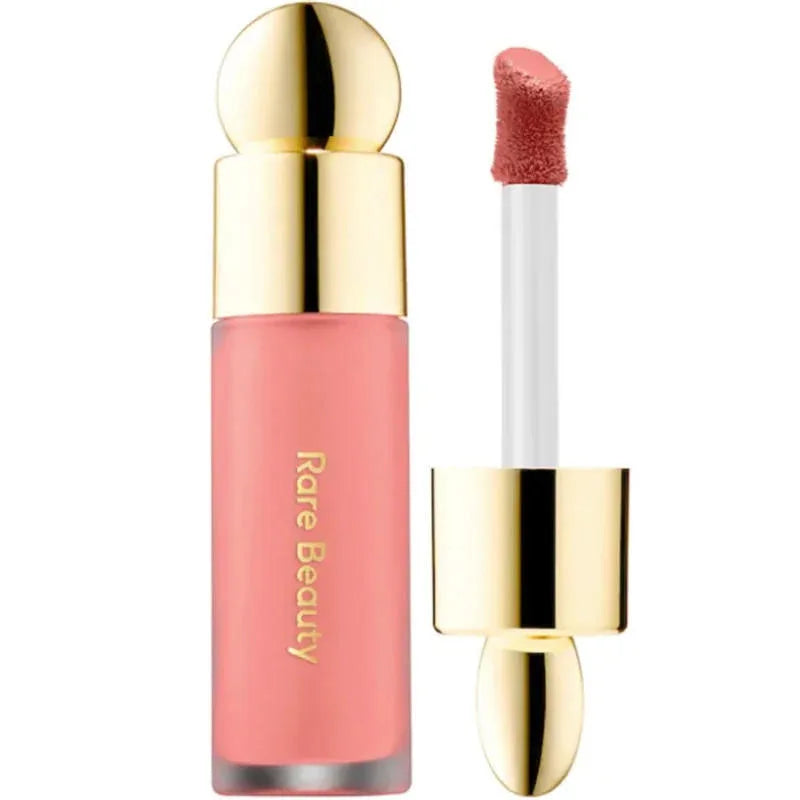 Rare Beauty soft peach liquid blush with gold cap and doe-foot applicator for a smooth, dewy finish.