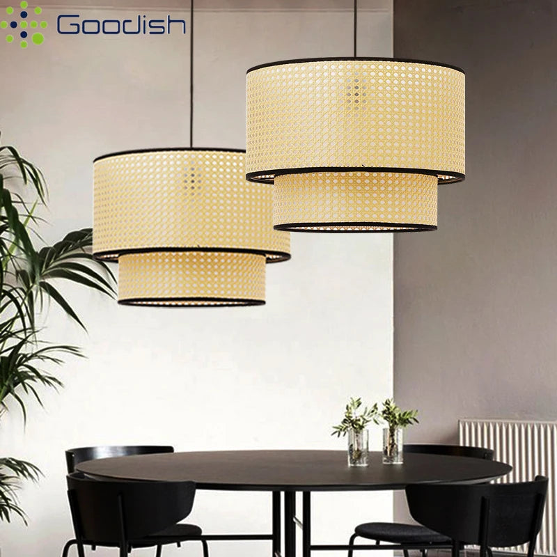 Two tiered, cylindrical pendant lights made of light-colored woven rattan with black trim, hanging over a dining table.