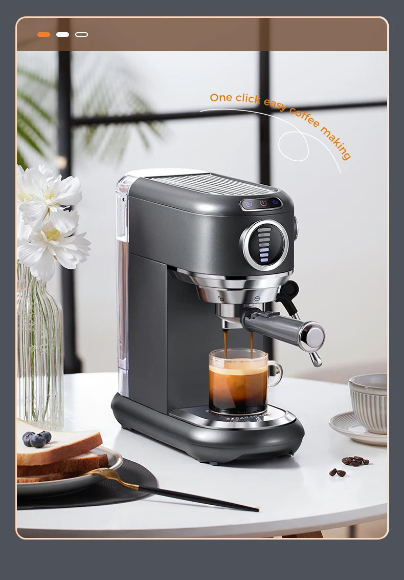 Dark grey compact espresso machine brewing coffee into a glass cup, featuring a metallic portafilter and sleek design.