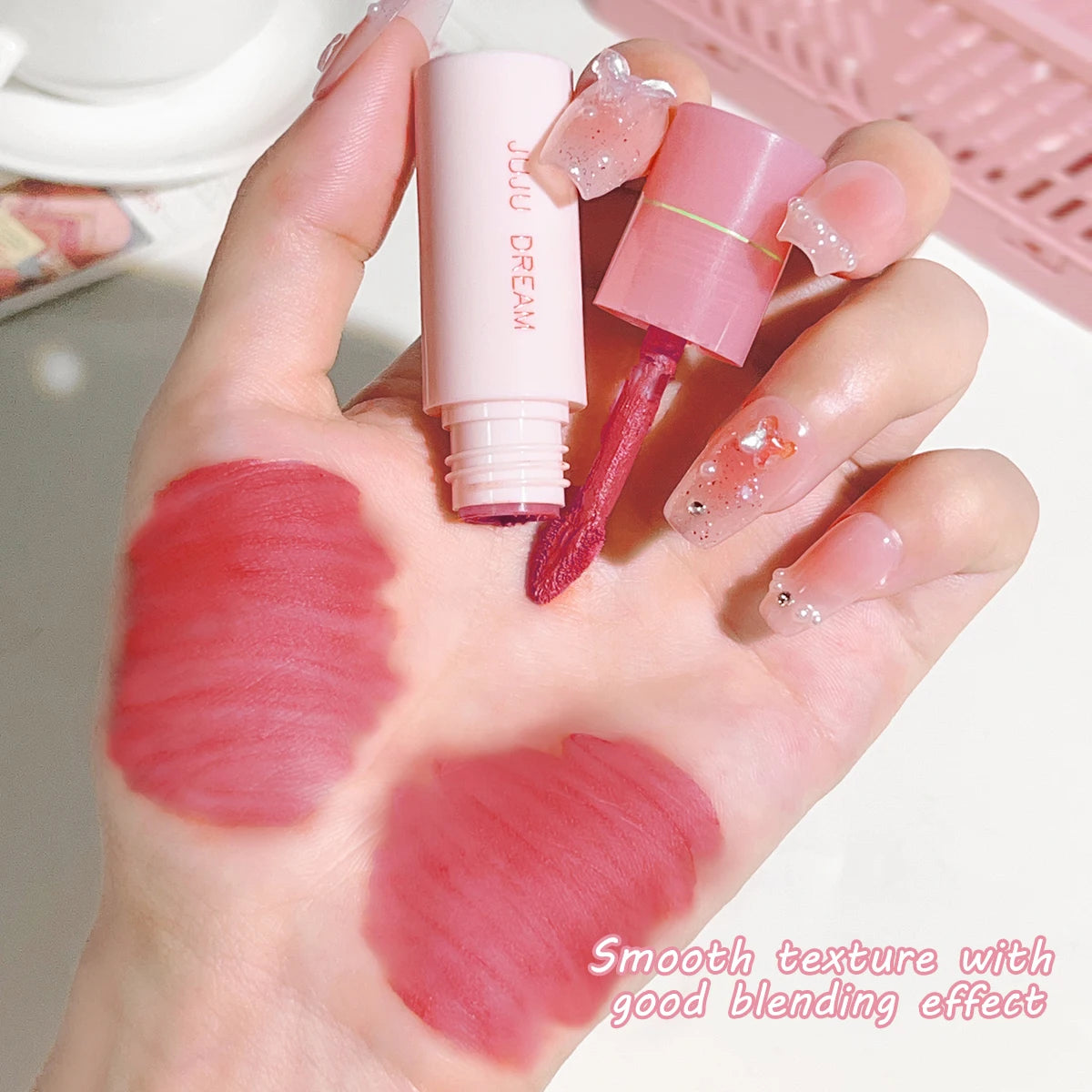JUJU DREAM matte lip glaze in pink packaging with velvet red lipstick swatches on hand for a smooth, non-stick finish.
