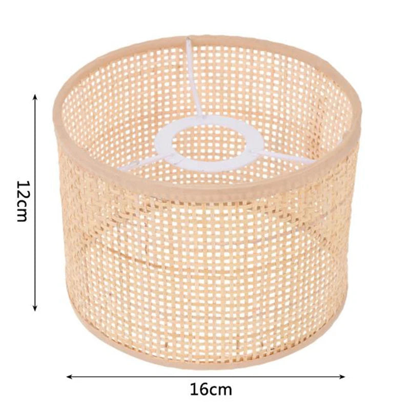 Cylindrical woven rattan lampshade, 16cm wide and 12cm high, with a white metal internal fitter for light fixtures.