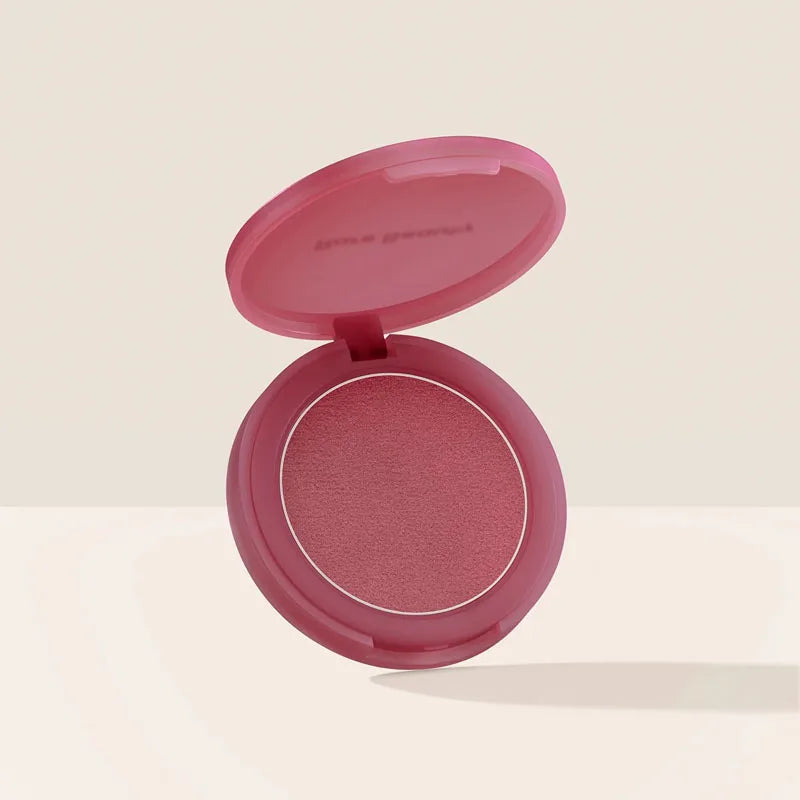 Rare Beauty powder blush in a soft pink compact, featuring a smooth, matte-finish berry rose pigment.