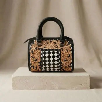 Genuine leather speedy duffle bag with floral tooling and black-and-white checkerboard panel, zipper closure.