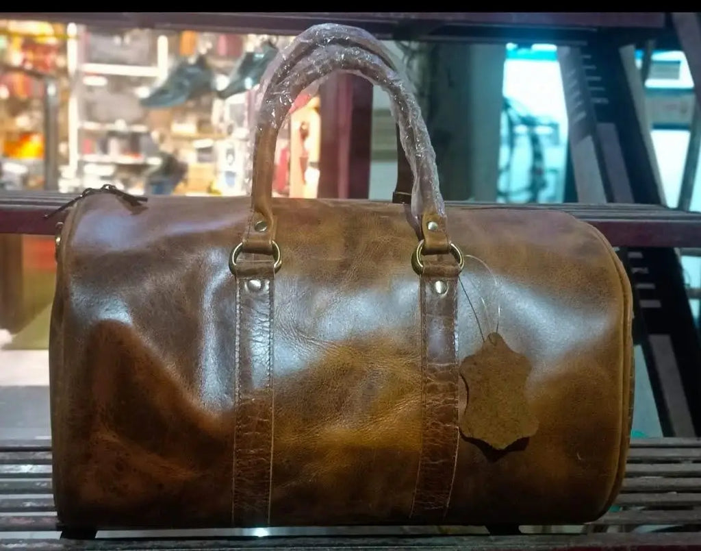 Brown full-grain leather gym trunk, large capacity durable travel duffel with sturdy handles and classic vintage style.