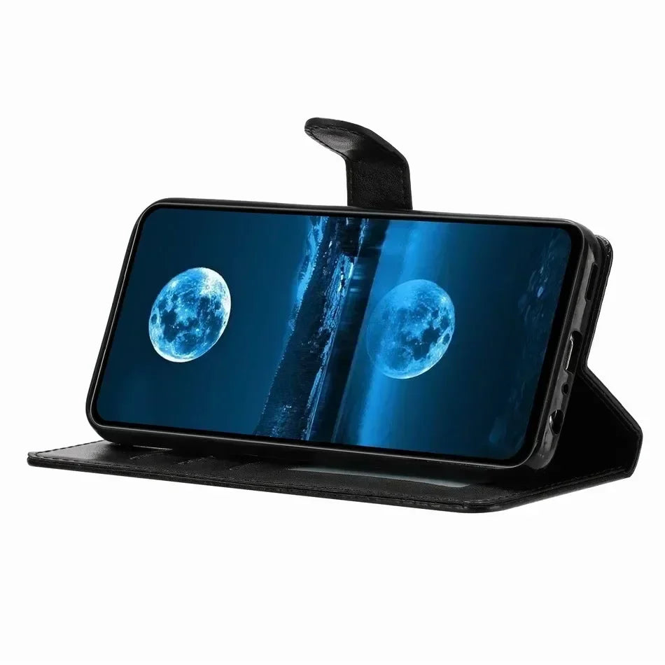 Black leather wallet-style phone case with magnetic clasp, propped horizontally for landscape viewing.